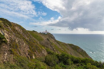 Long shot of a clif and coast of Sintra, Portugal, with the Cabo da Roca lighthouse