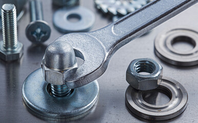 Wrench tightens steel cap nut in steel billet. Spanner, bolt, screw and nuts.