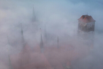 Thick fog over the old town of Gdansk with the St. Marys Basilica tower at sunrise, Poland - obrazy, fototapety, plakaty