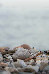 Close up image of the beach with sea in the distance with pebble stones