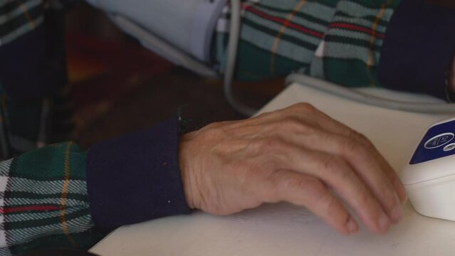close-up of a pensioner's hand measuring pressure using a tonometer while at home. an elderly person measures pressure on his own. home blood pressure monitor. health care in old age