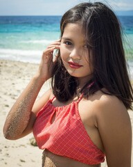 Fototapeta premium Beautiful Filipina in a red swimsuit posing at a beach in Capitancillo Island, Bogo city