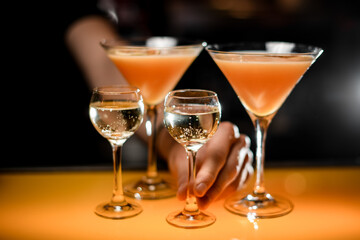 close-up view of glasses with vodka and cocktail on a bar counter
