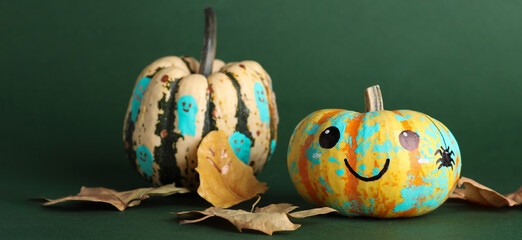 Painted Halloween pumpkins on green background