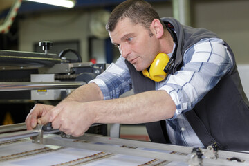 concentrated male carpenter in protective wear