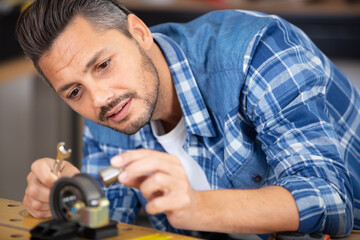 mechanic working with clamp and spanner on metal workpiece