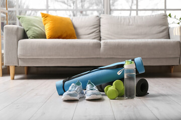 Sport equipment, shoes and bottle of water in room interior