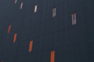 Architecture fragment of geometry with windows in orange frame on deep grey background. Pattern...