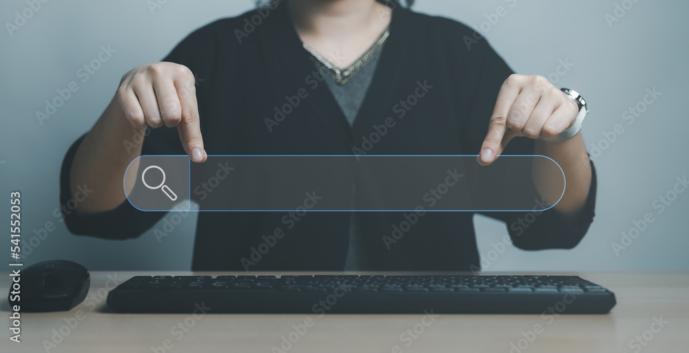 Fototapete woman hand showing a search bar, computer keyboard and mouse on table to searching for information. 