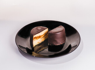 chocolate flan, Mexican chocoflan, chocolate biscuit cake and caramel custard pudding with a caramel sauce on top, on te dark wooden table