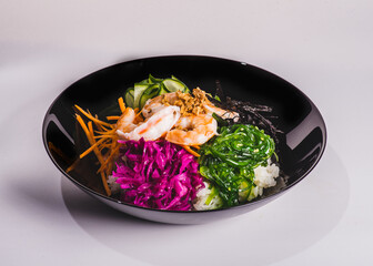 Fresh seafood recipe. Shrimp salmon poke in bowl on black wooden table background