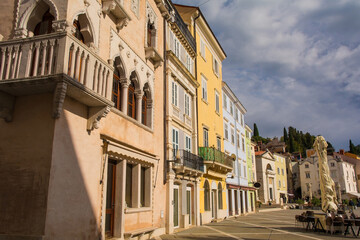 Historic buildings in Tartini Square in the medieval centre of Piran on the coast of Slovenia. The foreground building features trefoil headed lancet windows
