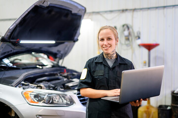 Fototapeta na wymiar Handsome mechanic job woman in uniform working on car