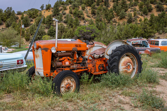 Old rusty orange colored vintage tractor parked in a junkyard, Arizona state, USA