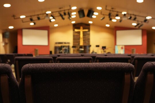 Empty Chairs Facing Cross And Worship Stage In Church