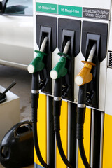 Three 95 metal-free petrol and sulphur-free diesel pump nozzles hanging on pump