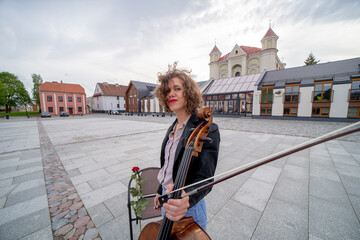 A female musician with a cello on the street