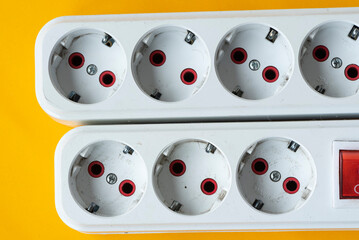 Many sockets on a yellow background. View from above. Energy saving