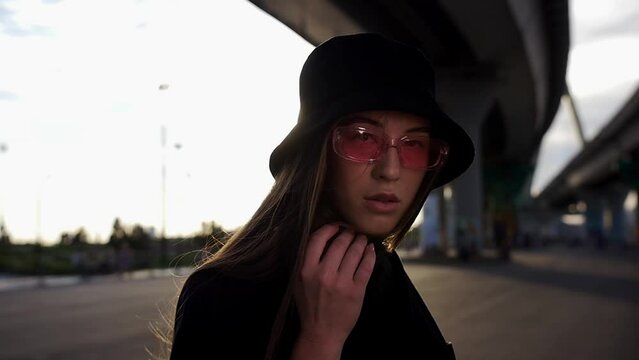 A woman in panama hat dancing under the bridge in slow motion