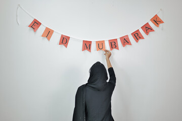 Women Holding a Eid Decoration Banner