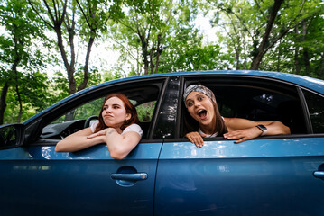 Two girlfriends fool around and laughing together in a car - 541560452