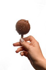 sweet macaron covered with chocolate icing on stick in female hand