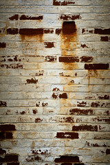 vertical background or backdrop of an old brick wall covered with grayed peeling white paint