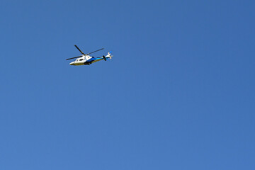 Unmarked executive helicopter in flight against a deep blue sky. No people. Copy space.