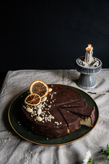 Ukrainian cheesecake syrnyk with chocolate and almond glaze cut on pieces on green plate.