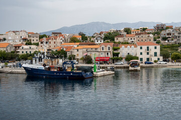 Fototapeta na wymiar Sumartin town port on Brac island, Croatia with anchored fishing boats coloured in blue