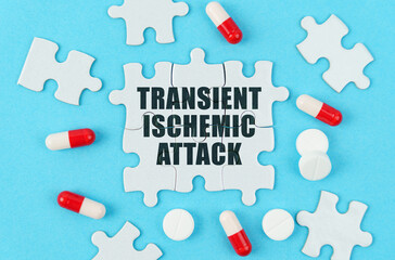 On a blue background, pills, capsules and puzzles with the inscription - transient ischemic attack