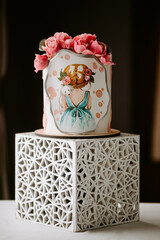 Front view of three-tiered wedding cake, decorated with fresh white orchids flowers and covered with tasty glaze, located on golden desk outdoor