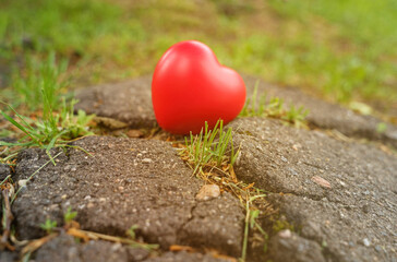 Obraz premium The heart stands on a crack in the asphalt - a symbol of discord in family relationships, divorce.