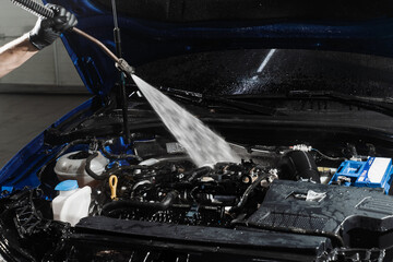 Washing car engine with with water in detailing auto service. Detailing cleaning motor from dust...