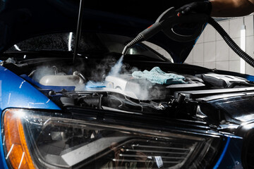 Steaming washing of motor of auto in detailing auto service. Process of steam cleaning car engine...