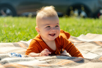 Obraz na płótnie Canvas Cute baby lying on the blanket on summer grass. Child outdoor.