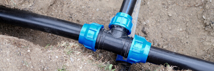 Installed PVC water pipes are assembled and laid in trench at construction site