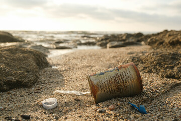 Used rusted metal box and microplastics debris discarded on sea ecosystem,environmental pollution damage