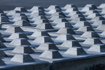Abtract pattern of pegs on top of concrete blocks.