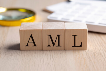 AML on wooden cubes with magnifier and calculator, financial concept background