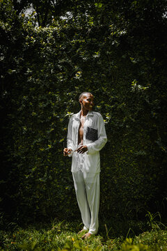 a black woman dressed fashionable posing for a portrait in a garden