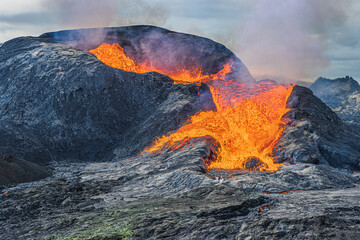 Active volcano about to erupt. strong lava flow from crater opening. Volcanic crater in Iceland. Volcanic landscape of Reykjanes Peninsula. Landscape in the evening with a cloudy sky © Marco