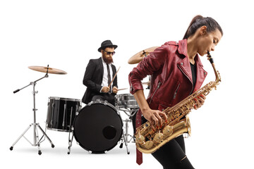 Young female playing a saxophone and a man playing drums in the back