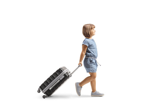 Full Length Profile Shot Of A Little Girl Walking And Pulling A Suitcase