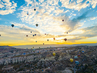 Breathtaking cloudy blue morning sky illuminated with warm sunshine. Sky filled with colourful hot-air balloons. Cappadocia, Turkey. High quality photo