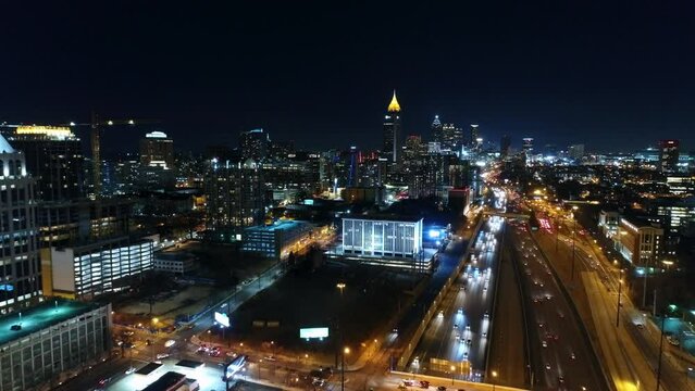 Aerial Backward Shot Of Illuminated Buildings And Cars In City Against Clear Sky - Atlanta, Georgia