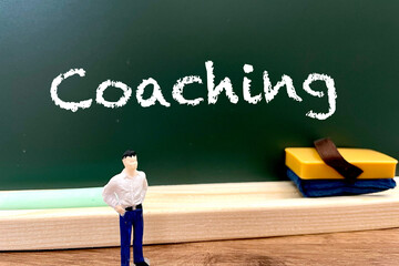 黒板の前のコーチングの文字と教える先生