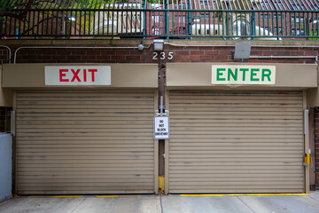 Obraz premium Entrance to the underground garage. Gate to the garage in the building. The office building is brown. High-quality photo