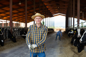 Portrait of confident young adult man engaged in livestock breeding farm