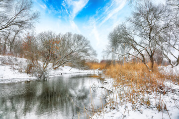 Winter landscape by a river in the sunset.